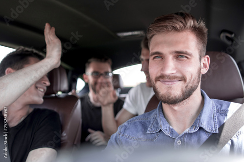 Group of happy friends on a car