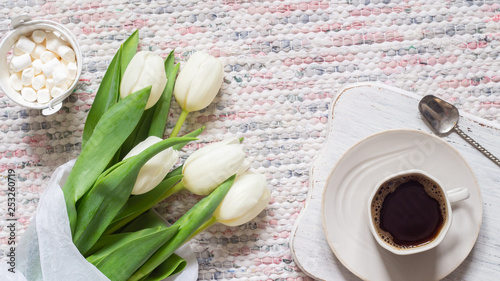 Bouquet of white tulips and cup of coffee