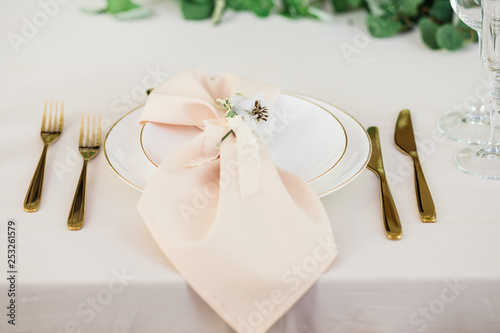 wedding table decorated by plates, knives and forks