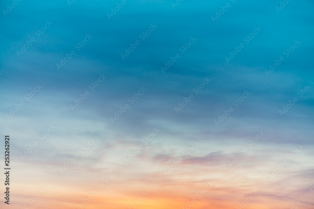 Fototapeta premium Sunset sky with violet yellow light clouds. Colorful smooth blue sky gradient. Natural background of sunrise. Amazing heaven at morning. Slightly cloudy evening atmosphere. Wonderful weather on dawn.