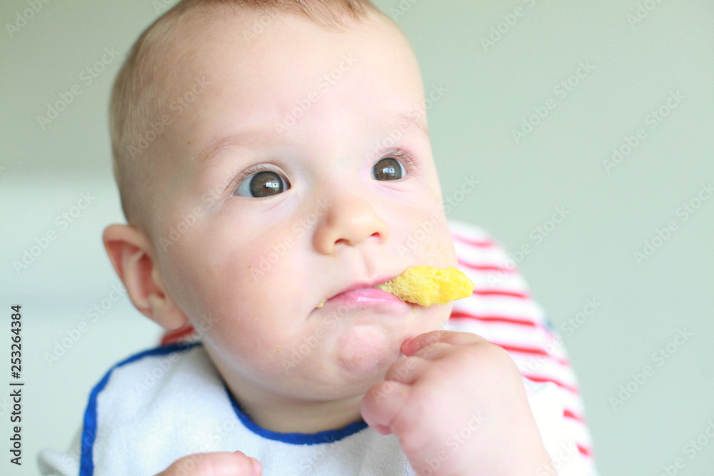 Cute little boy eating his first baby food Cute little boy eating his first baby food