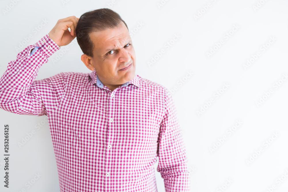 Middle age man wearing business shirt over white wall confuse and wonder about question. Uncertain with doubt, thinking with hand on head. Pensive concept. Middle age man wearing business shirt over white wall confuse and wonder about question. Uncertain with doubt, thinking with hand on head. Pensive concept.