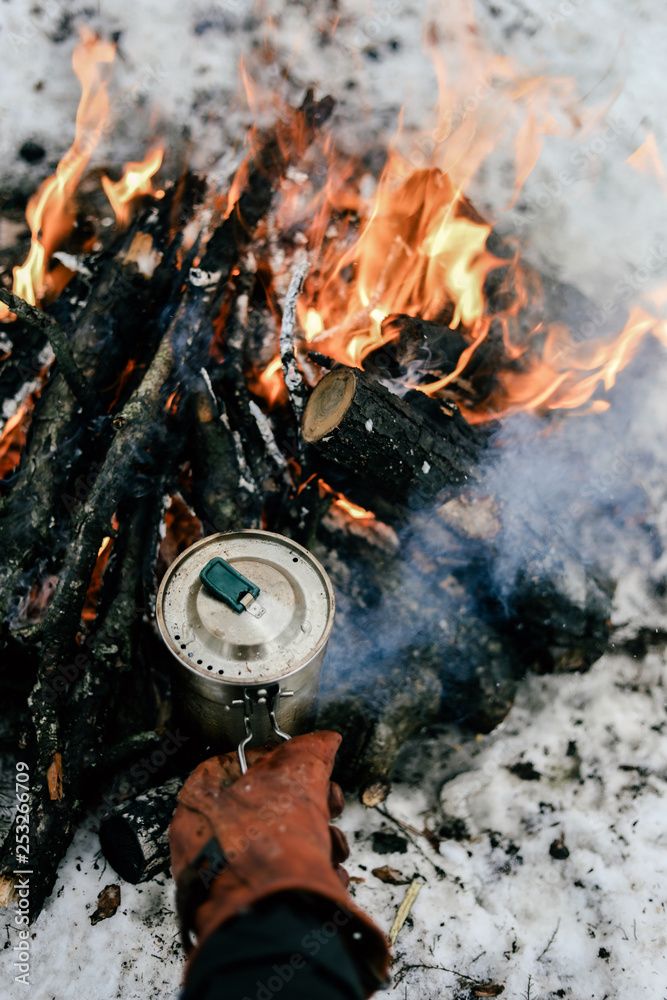 Camp fire in winter time, surrounded by snow against the background Camp fire in winter time, surrounded by snow against the background