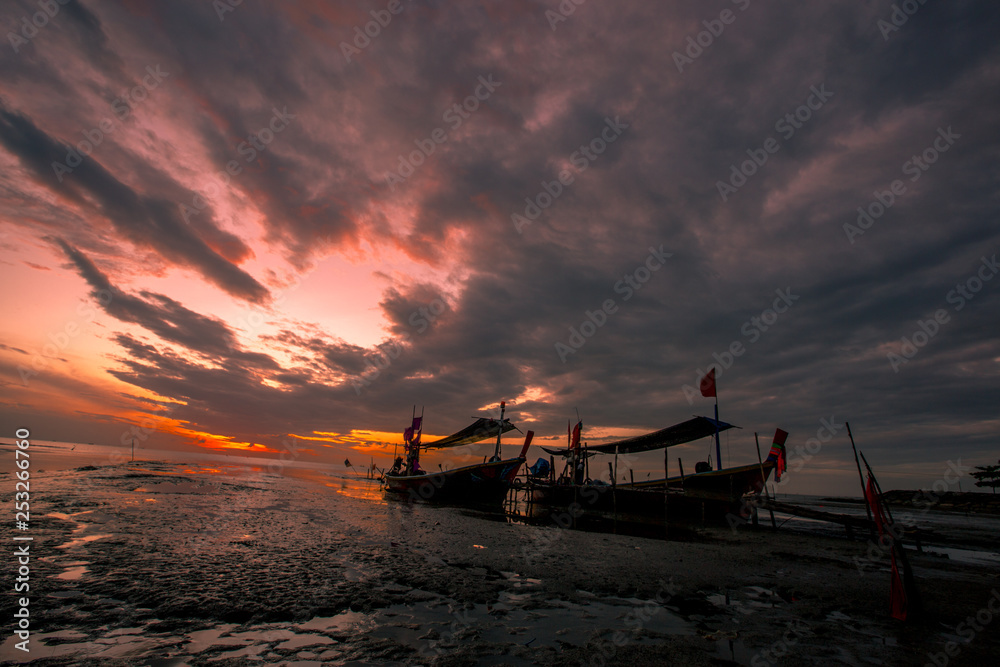 The background of the fishing boats is docked at the beach, with colorful skies in the morning, the natural beauty and the coexistence of fishermen on the waterfront