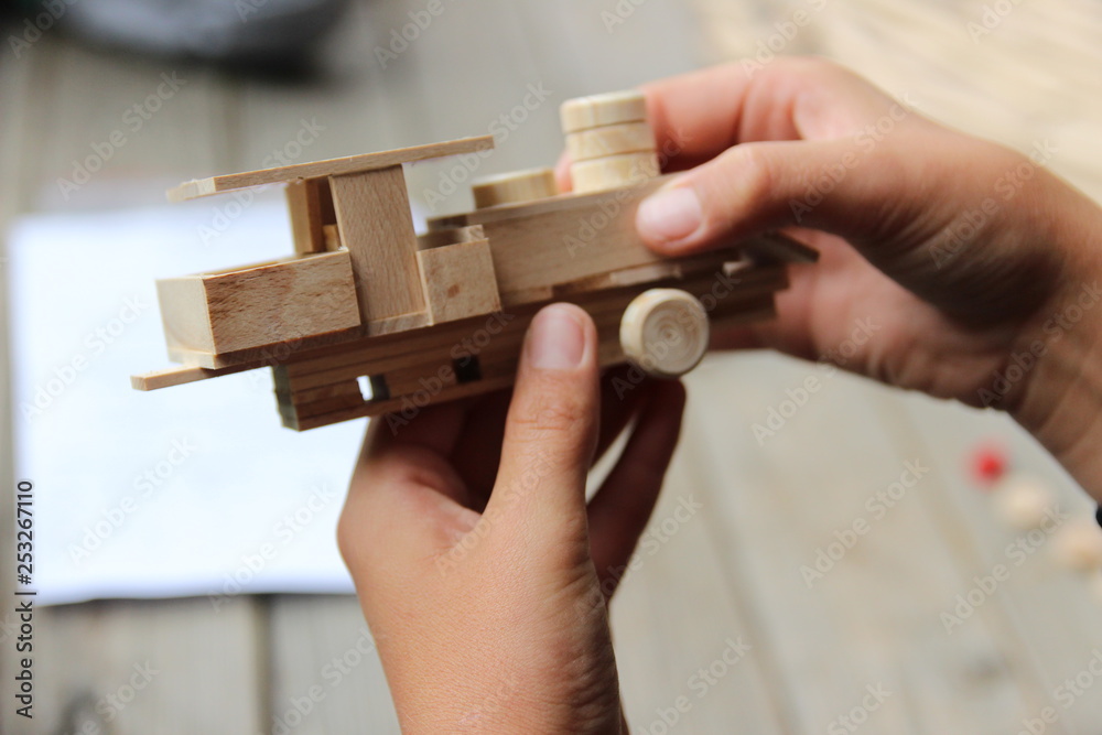 Fototapeta premium Child's hand, fold and stick a wooden toy