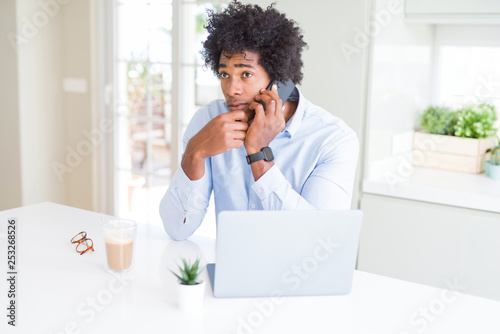 African American business man talking on the phone serious face thinking about question, very confused idea