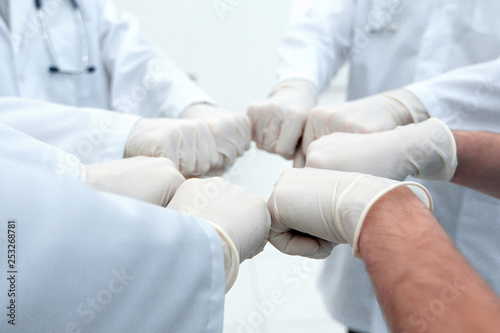 Doctors and nurses coordinate hands.