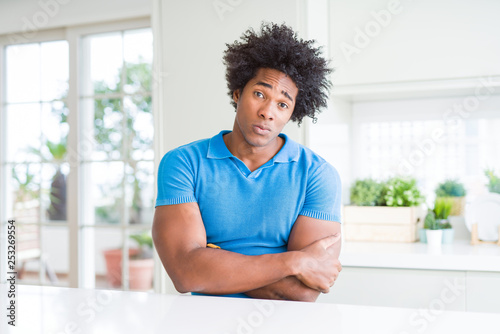 African American man at home skeptic and nervous, disapproving expression on face with crossed arms. Negative person.