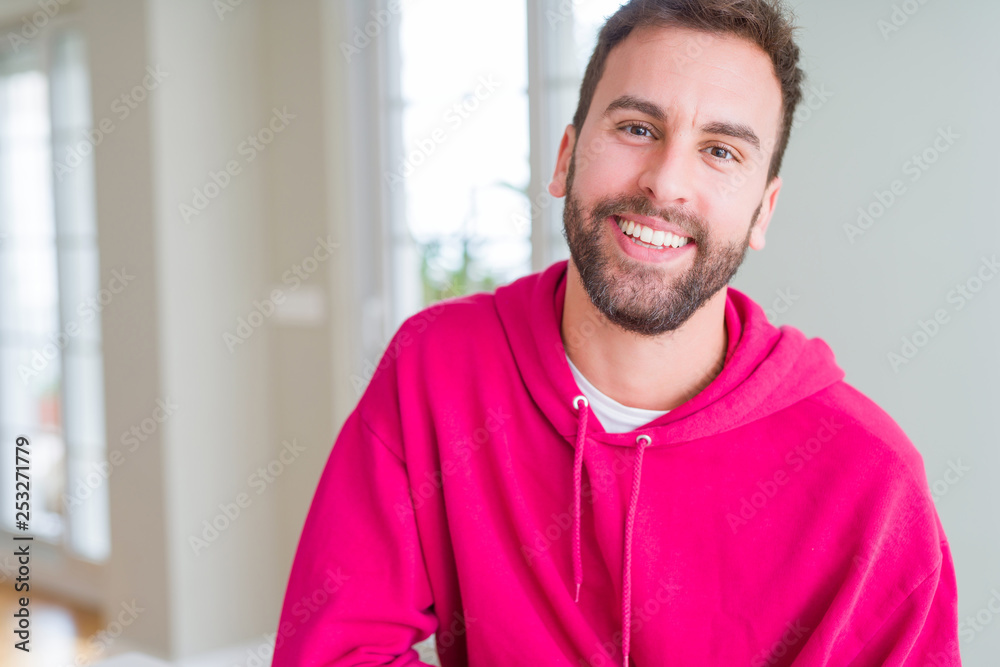 Handsome man wearing casual sweatshirt at home and smiling positive Handsome man wearing casual sweatshirt at home and smiling positive