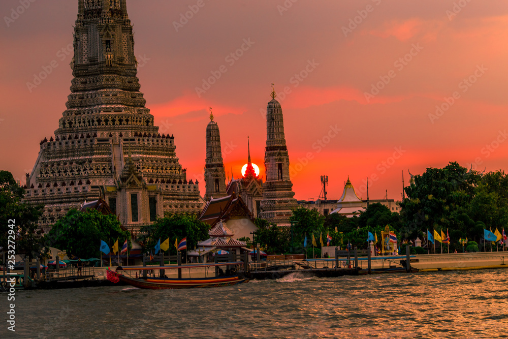 Obraz premium Twilight wallpaper in the evening,the sun going back to the horizon,Wat Arun Ratchawaramaram is a temple along the ChaoPhraya River is an important place and a beautiful tourist destination in Bangkok