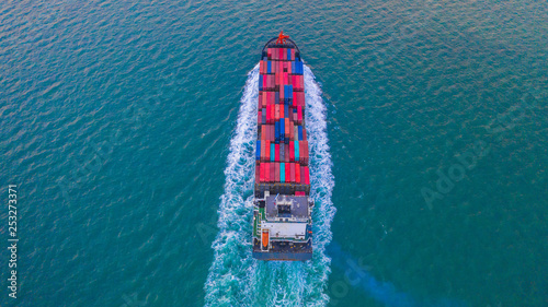 Tableau sur toile Container ship carrying container box for import and export business logistic and transportation by container ship in open sea, Aerial view