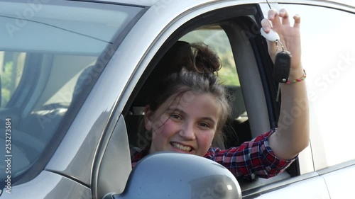 Car driver teenage girl happy showing car keys out window