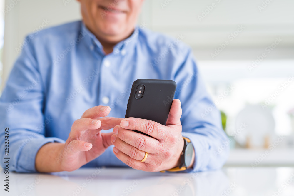 Close up of man hands using smartphone and smiling confident Close up of man hands using smartphone and smiling confident
