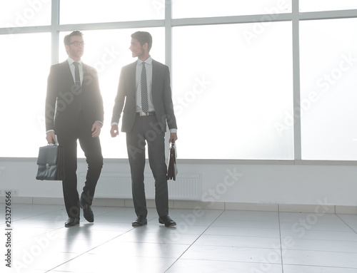 background image. two businessmen standing in the lobby of the office