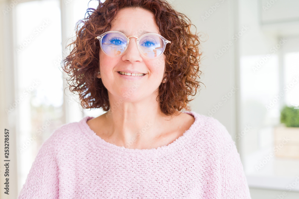 Beautiful senior woman wearing pink sweater and glasses with a happy and cool smile on face. Lucky person. Beautiful senior woman wearing pink sweater and glasses with a happy and cool smile on face. Lucky person.