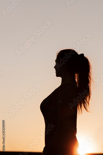 Silhouette einer Frau mit Pferdeschwanz Frisur im Gegenlicht