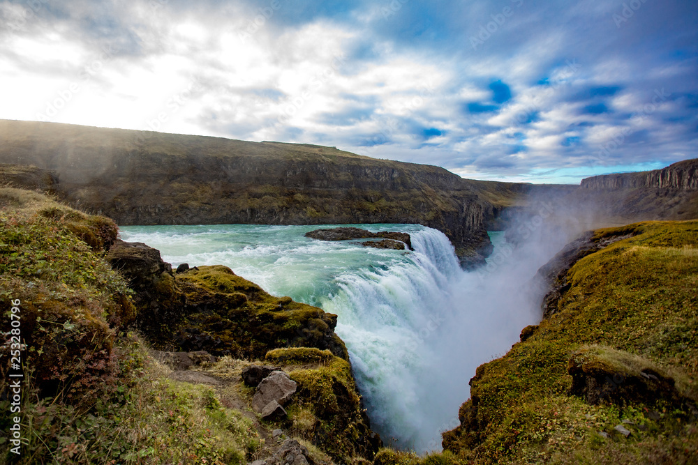 View of a waterfall in Iceland. Water flows from top to bottom. View of a waterfall in Iceland. Water flows from top to bottom.