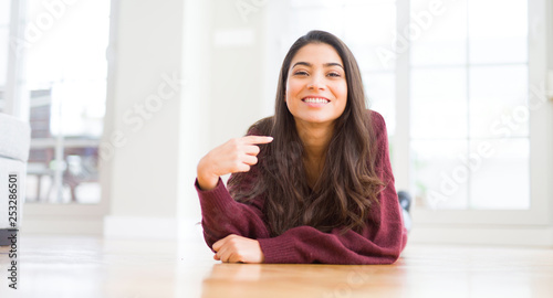 Young beautiful woman lying on the floor at home with surprise face pointing finger to himself Free Download Young beautiful woman lying on the floor at home with surprise face pointing finger to himself - GFXLoad