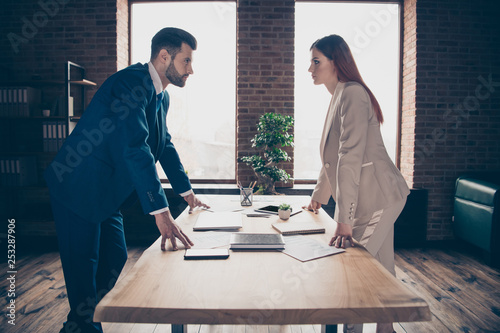 Close up photo two partners she her business lady he him his guy I will get promotion competitive mood strict look eyes who is winner concept stand office table wearing formal wear suit