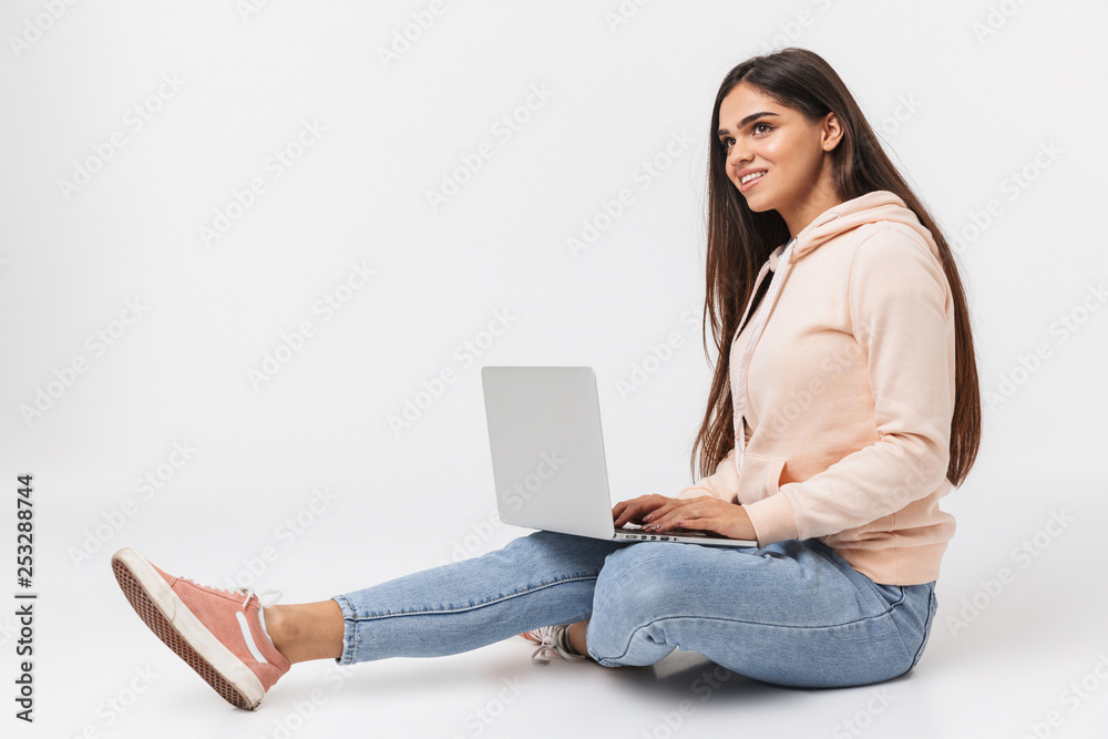 Naklejka premium Happy young girl sitting on a floor