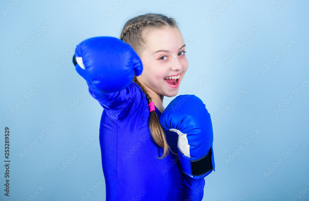 With great power comes great responsibility. Boxer child in boxing gloves. Girl cute boxer on blue background. Rise of women boxers. Female boxer change attitudes within sport. Feminism concept With great power comes great responsibility. Boxer child in boxing gloves. Girl cute boxer on blue background. Rise of women boxers. Female boxer change attitudes within sport. Feminism concept