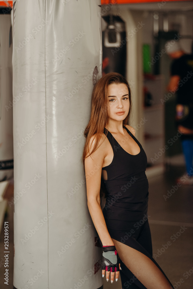 Woman boxer training hard. Young adult woman doing kickboxing training in gym. Woman boxer training hard. Young adult woman doing kickboxing training in gym.