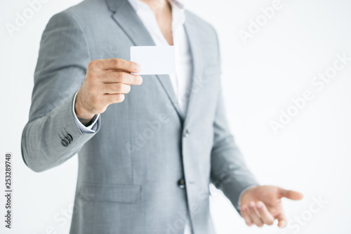 Close up of a businessman hand holding a business card isolated on a white background.Businessman with a blank business card on white light background.Mock up.