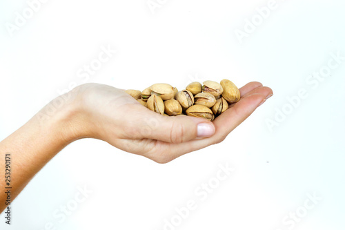 Young woman hand holding pistachios on isolated white background.