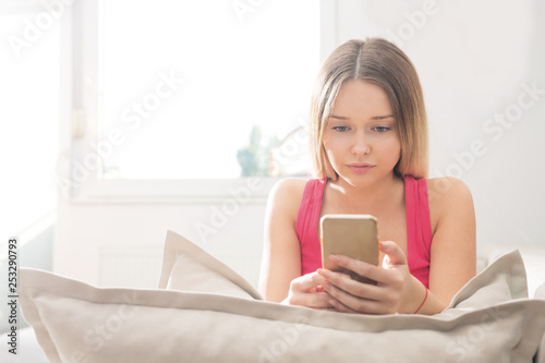 Young woman using smartphone on sofa