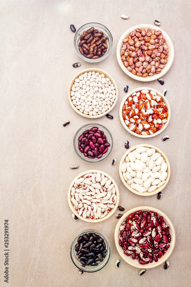 Assortment of beans on a stone background. Crimson cranberry, red, painted pony, black turtle, brown, black-eyed, Jacob's Cattle (heirloom) and lima, top view. Assortment of beans on a stone background. Crimson cranberry, red, painted pony, black turtle, brown, black-eyed, Jacob's Cattle (heirloom) and lima, top view.
