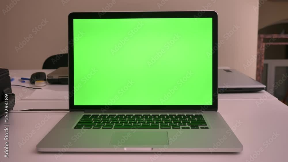 Closeup shoot of green chroma screen of the laptop lying on the laptop in the office indoors straight view