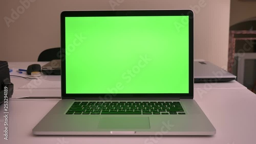 Closeup shoot of green chroma screen of the laptop lying on the laptop in the office indoors straight view