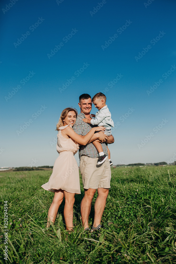 Family walking in field carrying young baby boy Family walking in field carrying young baby boy