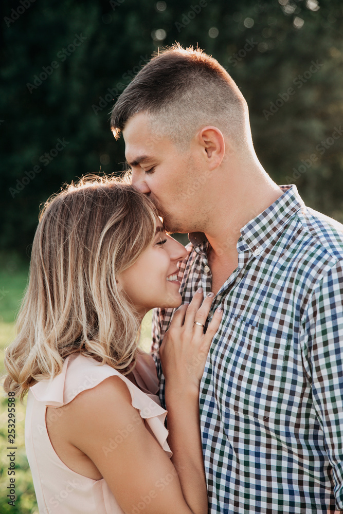 Young couple in love outdoor.Stunning sensual portrait of young couple posing in summer in field Young couple in love outdoor.Stunning sensual portrait of young couple posing in summer in field