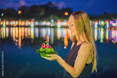 Young woman celebrates Loy Krathong, Runs on the water. Loy Krathong festival, People buy flowers and candle to light and float on water to celebrate the Loy Krathong festival in Thailand photo