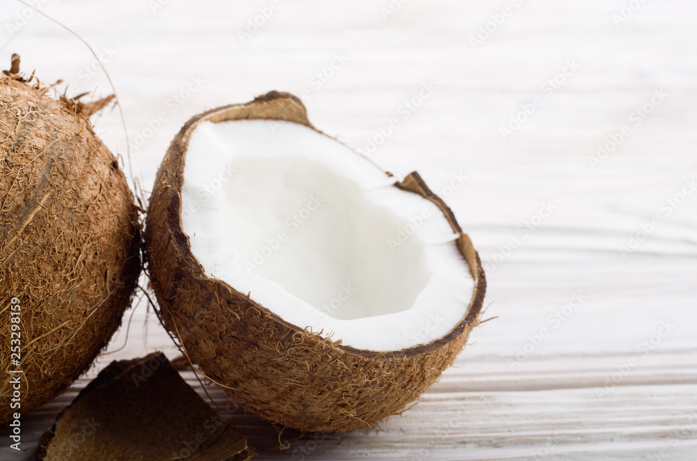 Coconut and shell pieces on white wooden table Coconut and shell pieces on white wooden table