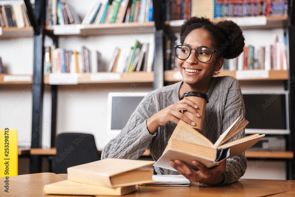 Happy young student girl studying at the library Happy young student girl studying at the library