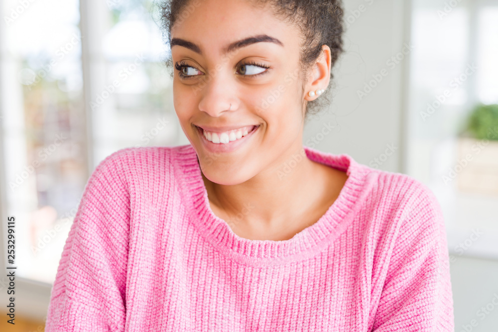 Beautiful young african american woman with afro hair smiling looking side and staring away thinking. Beautiful young african american woman with afro hair smiling looking side and staring away thinking.