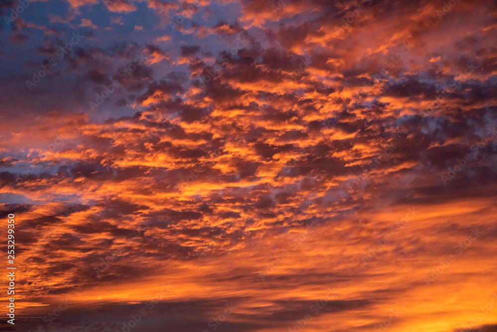 A majestic and awe-inspiration combination of deep blue sky and fiery orange and yellow clouds at sunset.