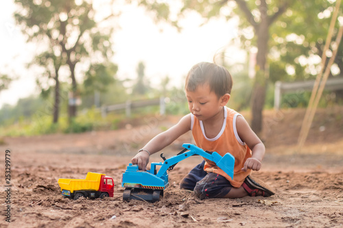 baby playing toy on soil outdoor