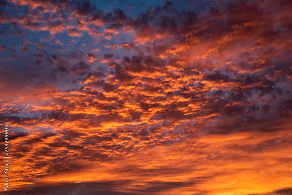 A majestic and awe-inspiration combination of deep blue sky and fiery orange and yellow clouds at sunset.