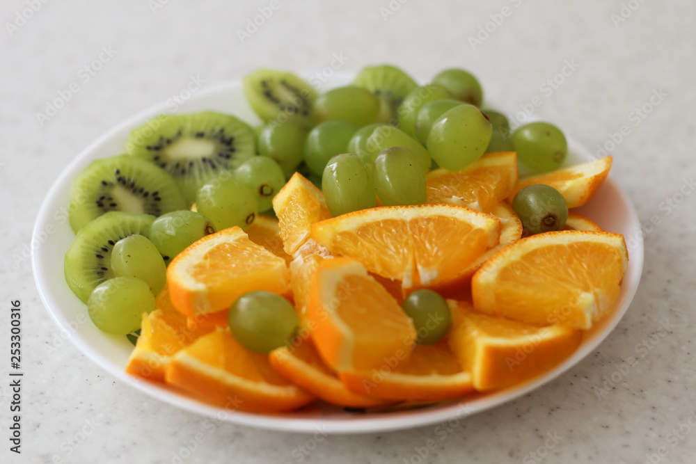 white fruit plate with grapes, orange, kiwi