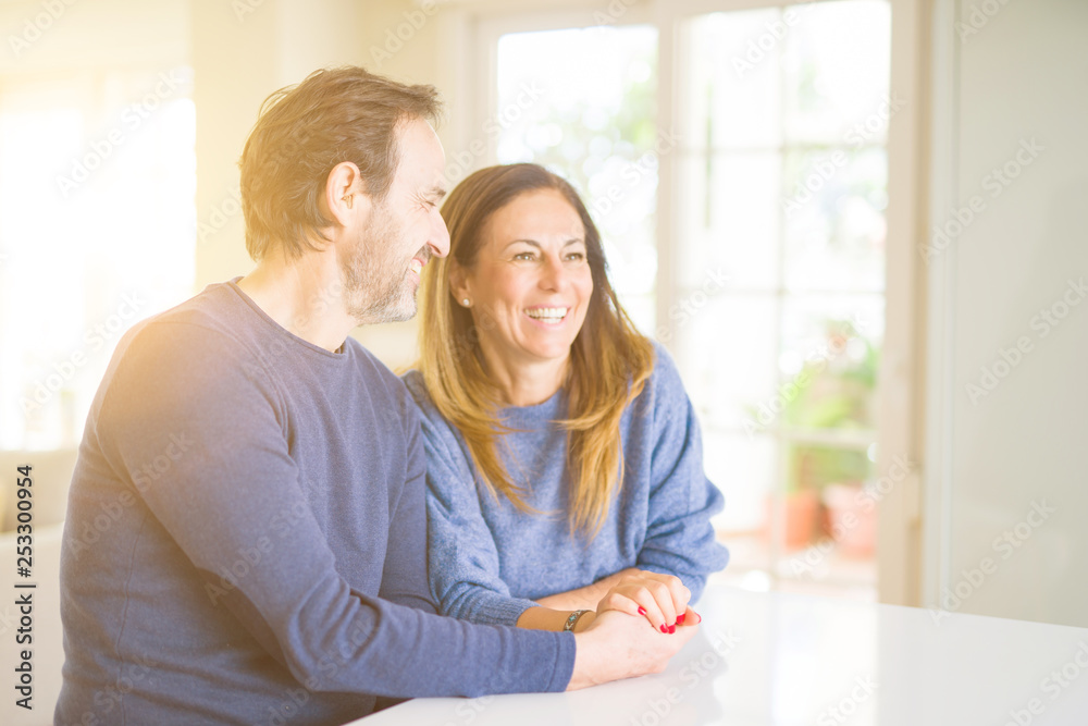 Romantic middle age couple sitting together at home Romantic middle age couple sitting together at home