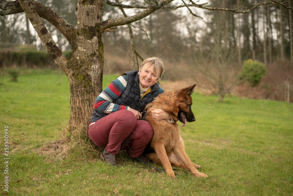Mature woman with pet Alsatian in field Mature woman with pet Alsatian in field
