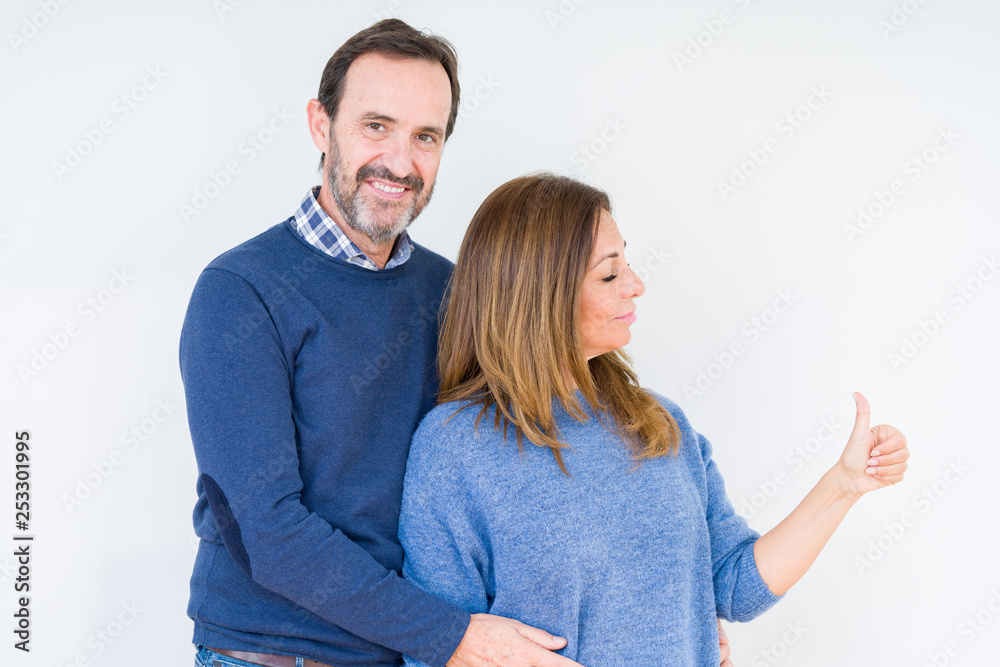 Beautiful middle age couple in love over isolated background Looking proud, smiling doing thumbs up gesture to the side Beautiful middle age couple in love over isolated background Looking proud, smiling doing thumbs up gesture to the side