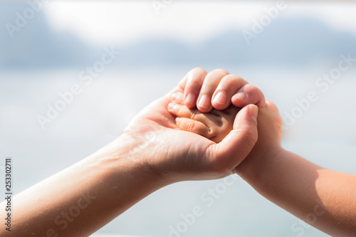 Mother holding hold her child's hand, close up.