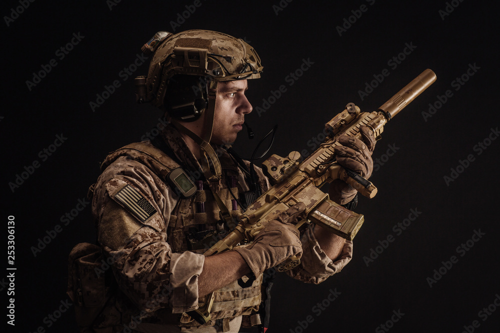 Special forces United States soldier or private military contractor holding rifle. Image on a black background. war, army and people concept Special forces United States soldier or private military contractor holding rifle. Image on a black background. war, army and people concept