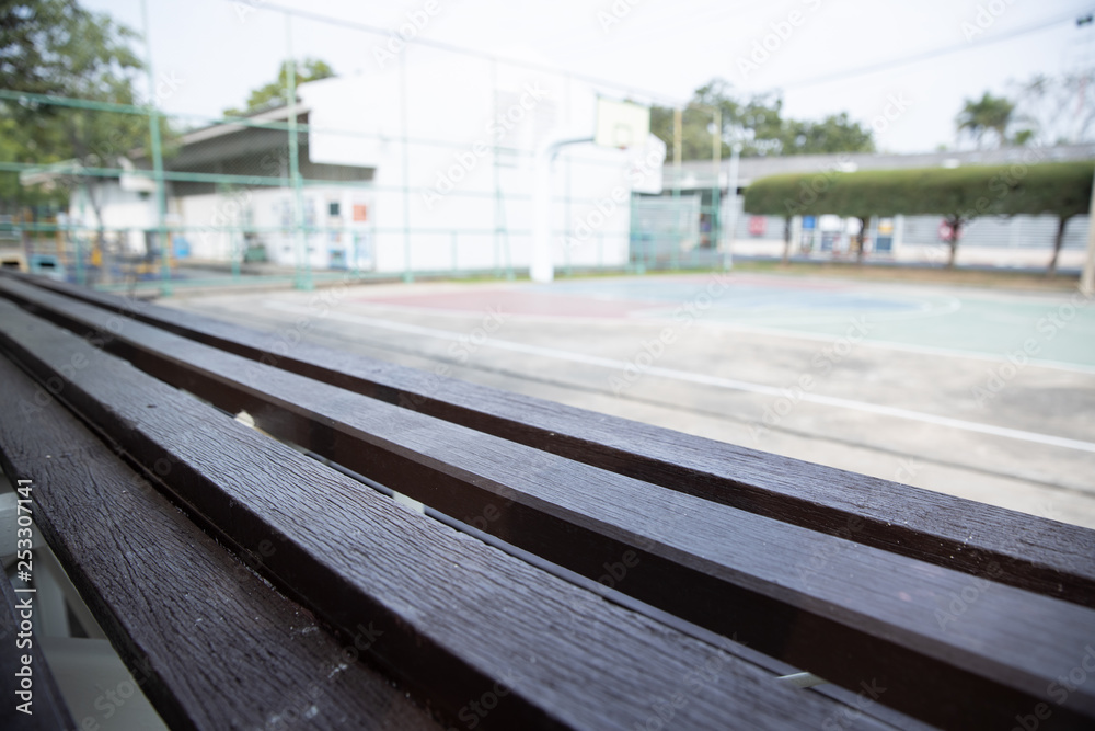 Fototapeta premium empty old wooden bleachers with blurred basketball court background.