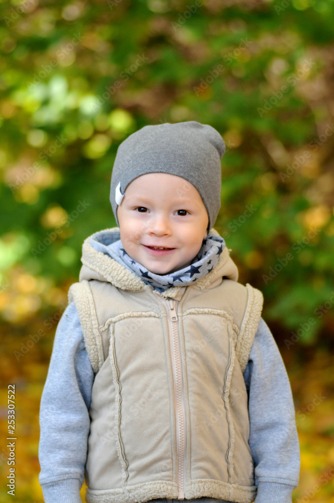 Two years old boy standing on falling autumn leaves Two years old boy standing on falling autumn leaves