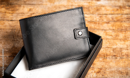 Black leather wallet on a wooden table